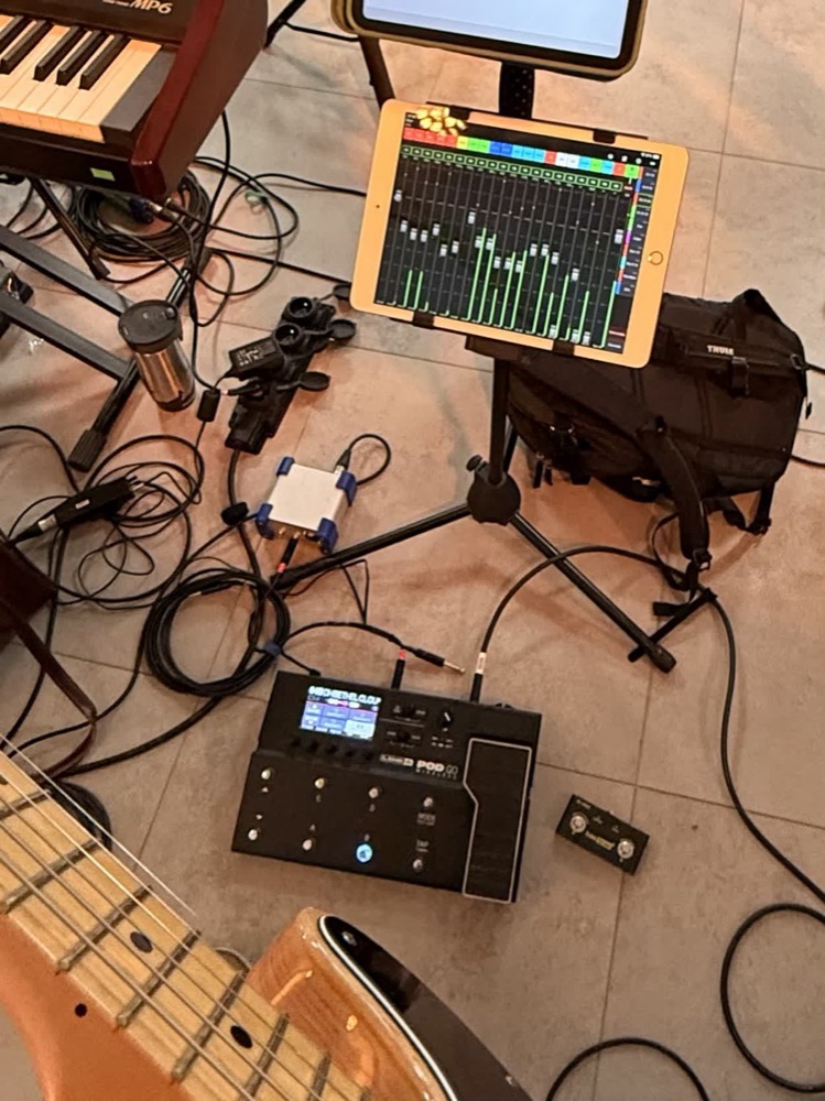 Sprzęt rozłożony na podłodze: gitara, multiefekt, tablet z mikserem, kable